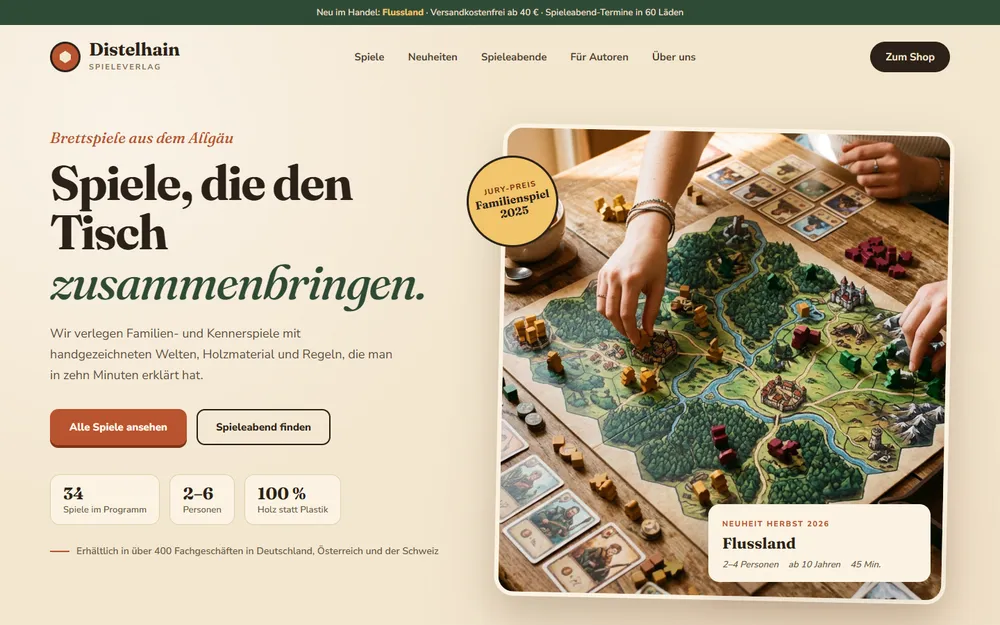 Beispiel-Website für einen Brettspielverlag: Hände setzen Holzfiguren auf ein illustriertes Spielbrett, daneben die Neuheit des Herbstes